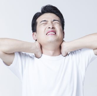목을 짚은 채로 얼굴을 찡그린 남성