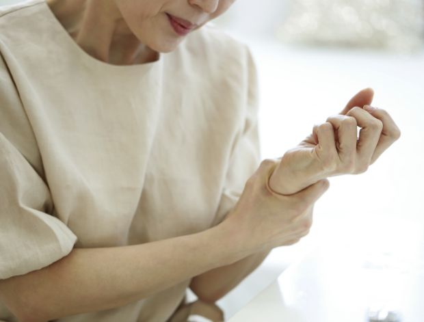 손목을 부여잡은 중년 여성